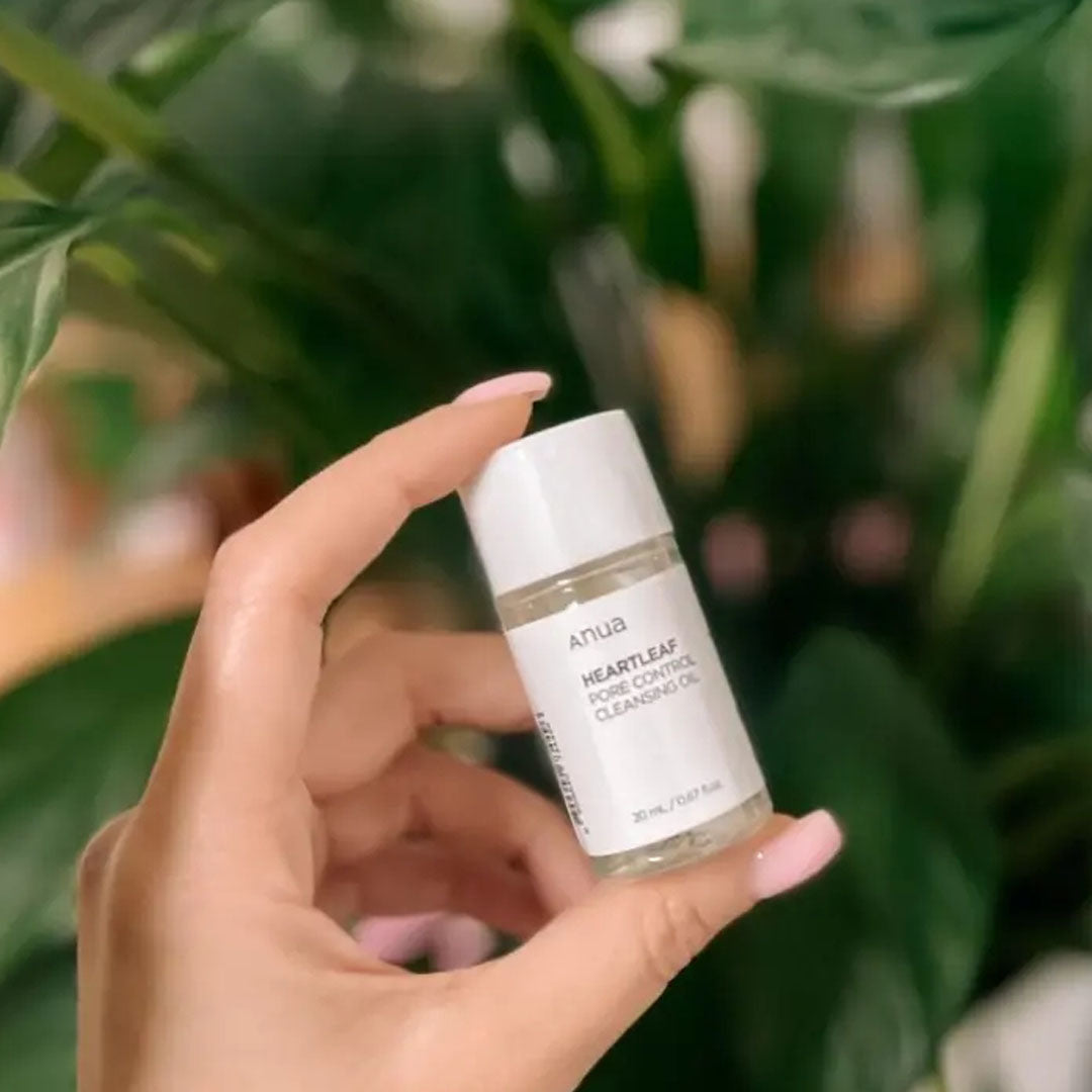 hand holding Anua Heartleaf Pore Control Cleansing Oil Mini bottle