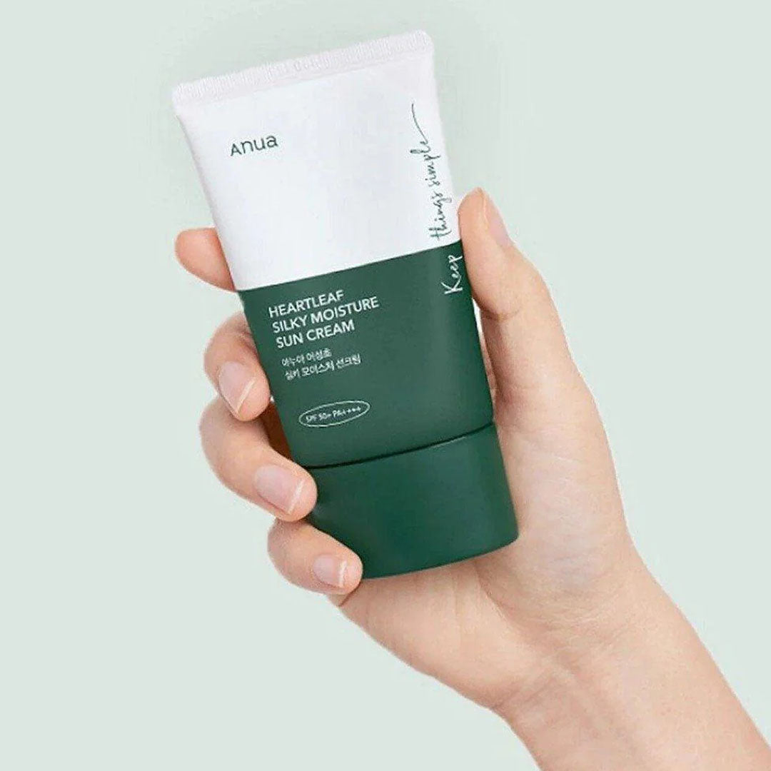 hand holding Anua Heartleaf Silky Moisture Sun Cream tube