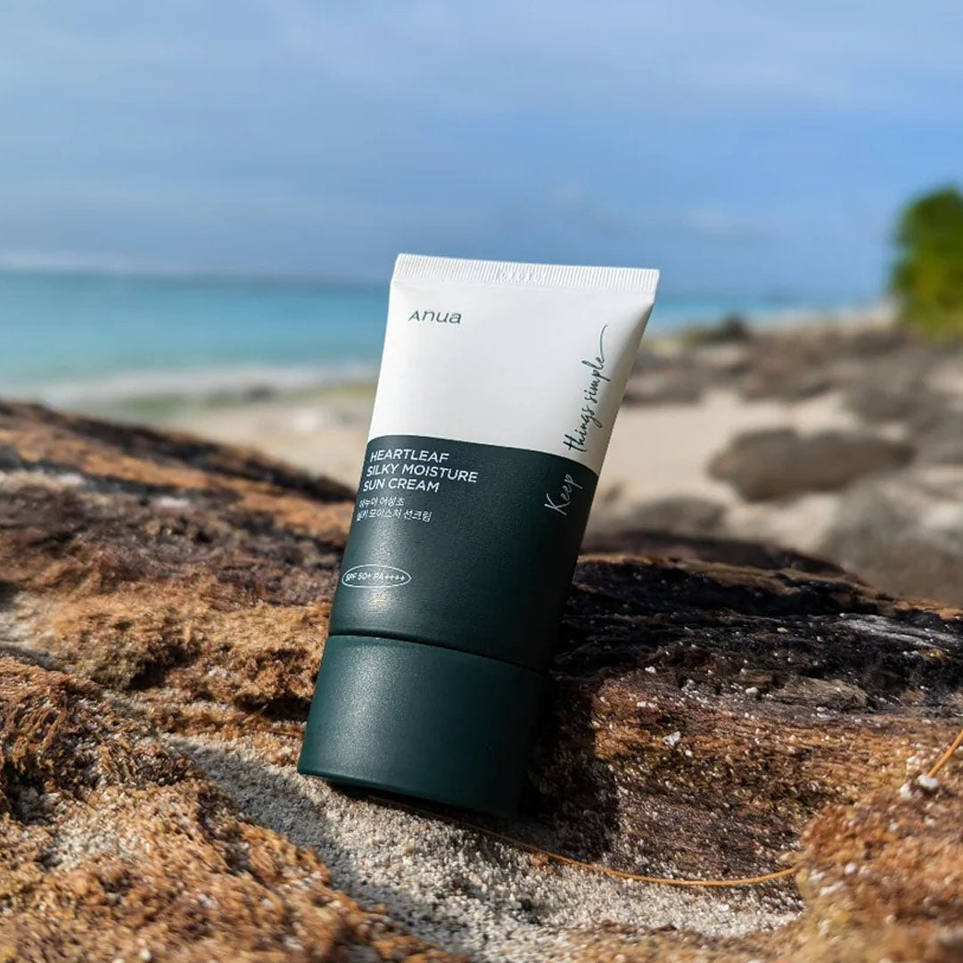 Anua Heartleaf Silky Moisture Sun Cream tube on a rocky surface