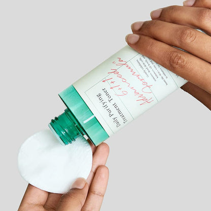 hand dispensing AXIS-Y Daily Purifying Treatment Toner on to a pad  
