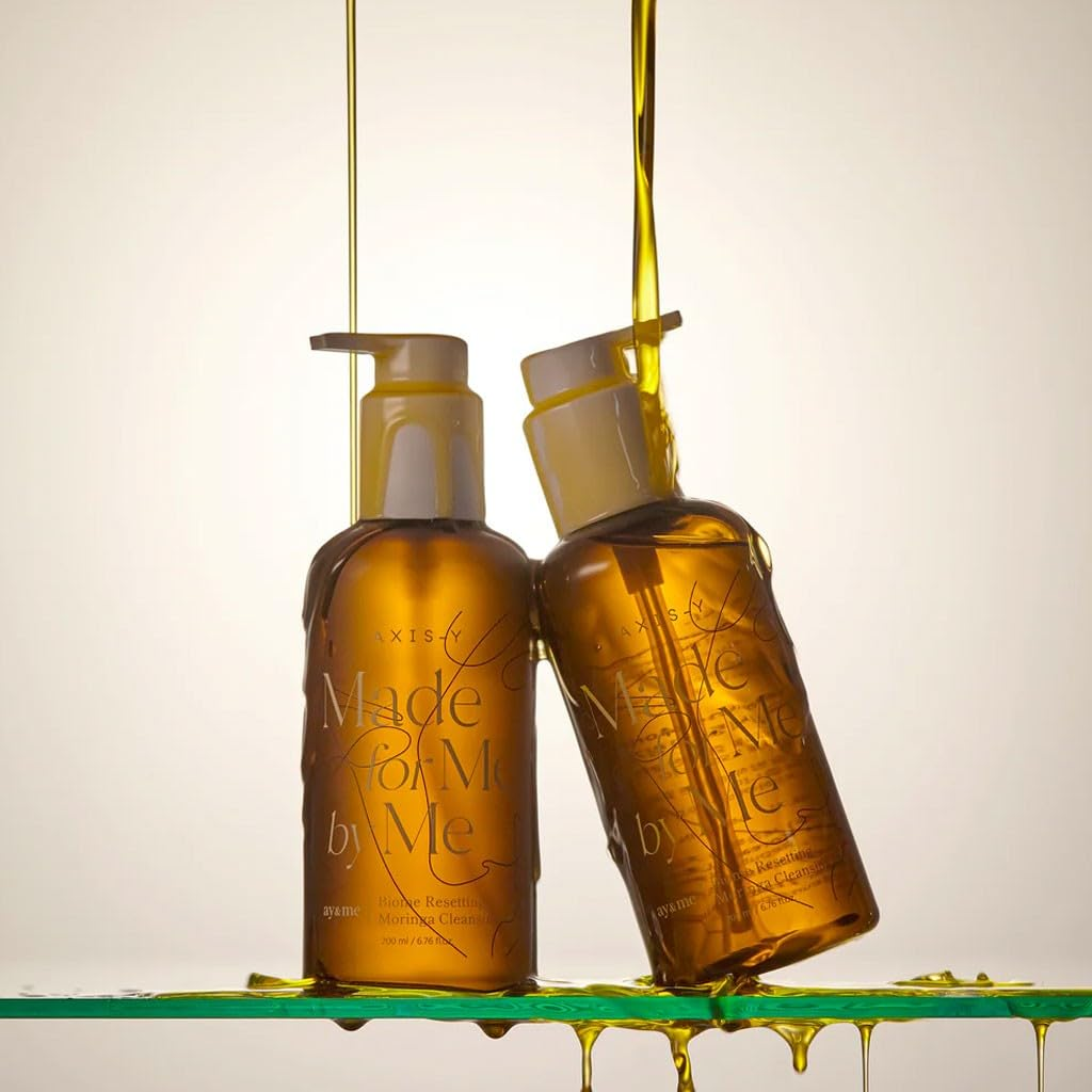 AXIS-Y Biome Resetting Moringa Cleansing Oil bottles drenched in product