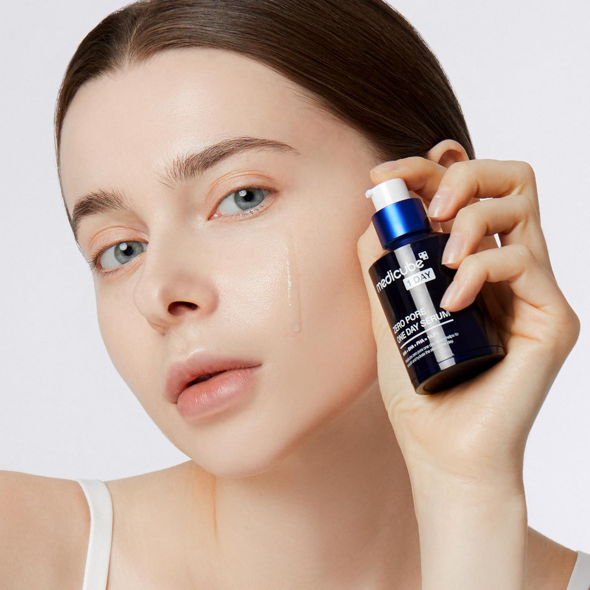 woman applying medicube zero pore one day serum on her face