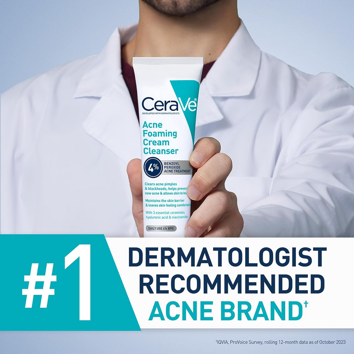 person in a white coat holding CeraVe Acne Foaming Cream Cleanser tube