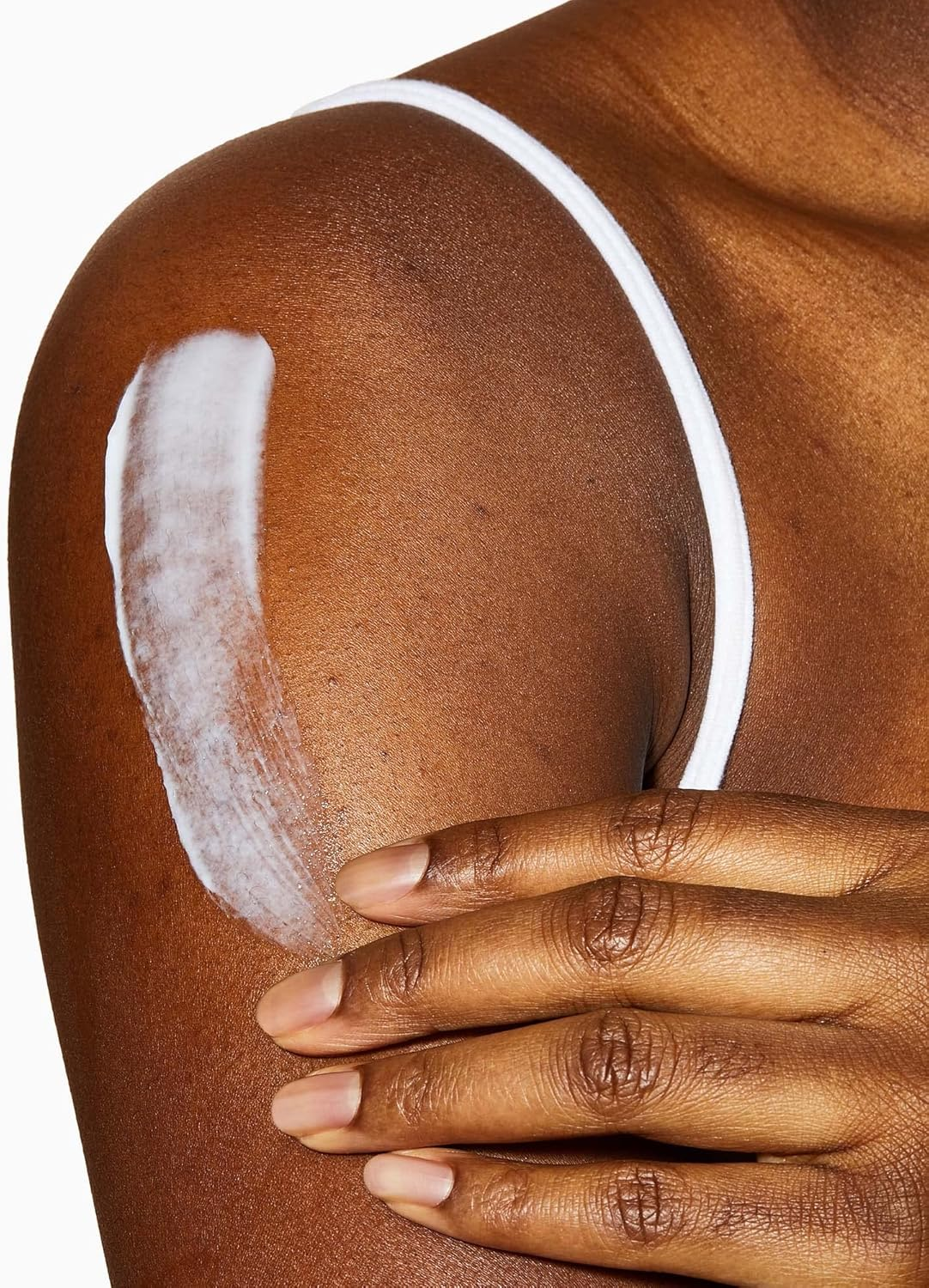 person applying CeraVe Moisturising Cream For Dry to Very Dry Skin on her shoulder.