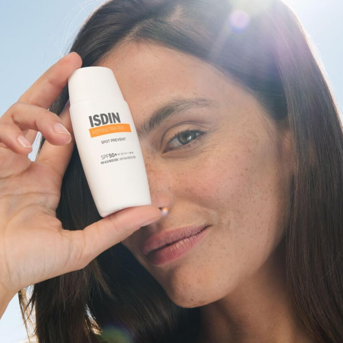 woman holding ISDIN Fotoultra 100 Spot Prevent SPF 50+ bottle
