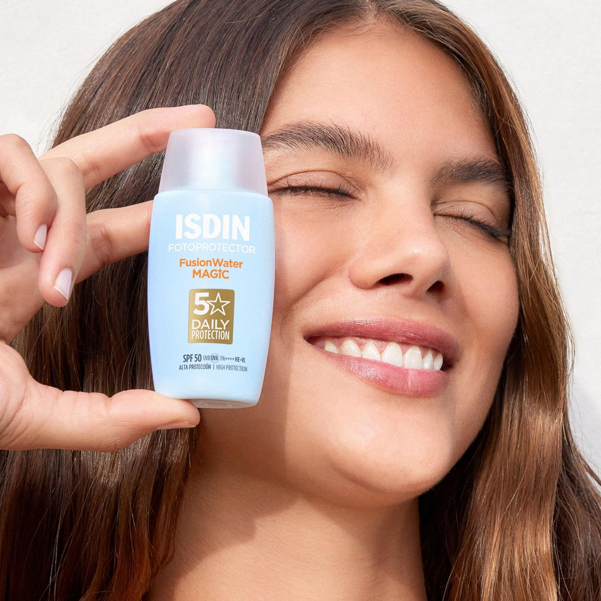 woman holding ISDIN Fusion Water Magic SPF50 bottle