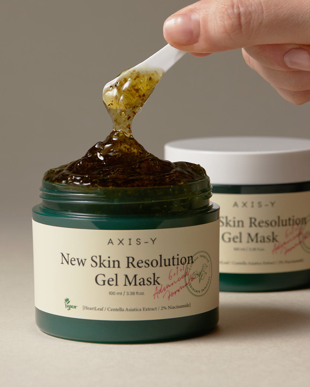 hand scooping out Axis-Y New Skin Resolution Gel Mask with applicator